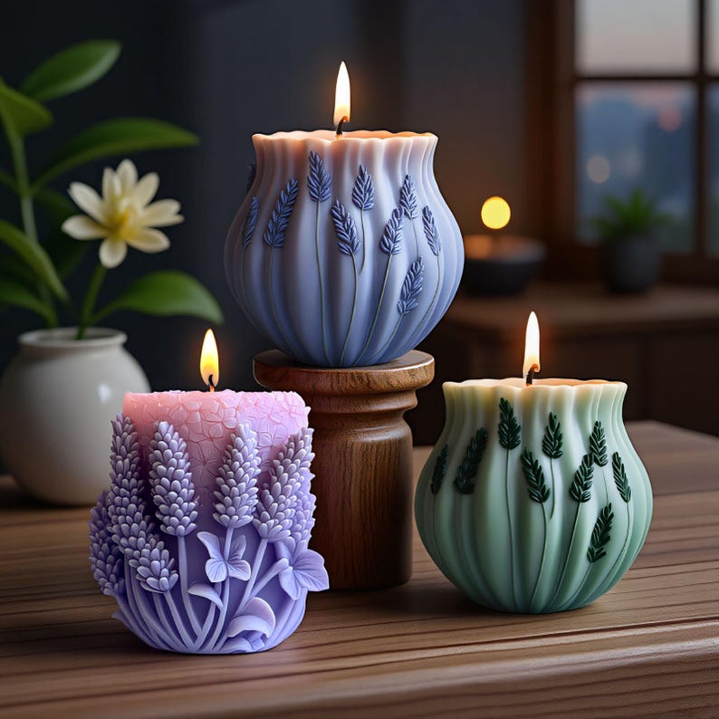May include: Three lit, decorative candles on a wooden surface. The candles are in shades of blue, pink, and green, each with a unique floral design. The blue candle is on a wooden stand. The candles have a wavy top edge.