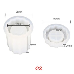 May include: Two white silicone molds for making candles. The larger mold is 9.5 inches wide and 4.1 inches tall. The smaller mold is 9.5 inches wide and 1.2 inches tall. Both molds have a scalloped edge.