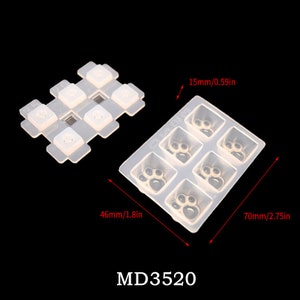 May include: A clear silicone mold with six paw print designs. The mold is 2.75 inches wide and 1.8 inches long. The mold is labeled "MD3520".