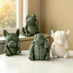May include: Four ceramic figurines: a green frog, a green bulldog, a green turtle, and a white Highland cow. Each figurine is making a rude hand gesture. The frog, bulldog, and turtle are green, while the cow is white.
