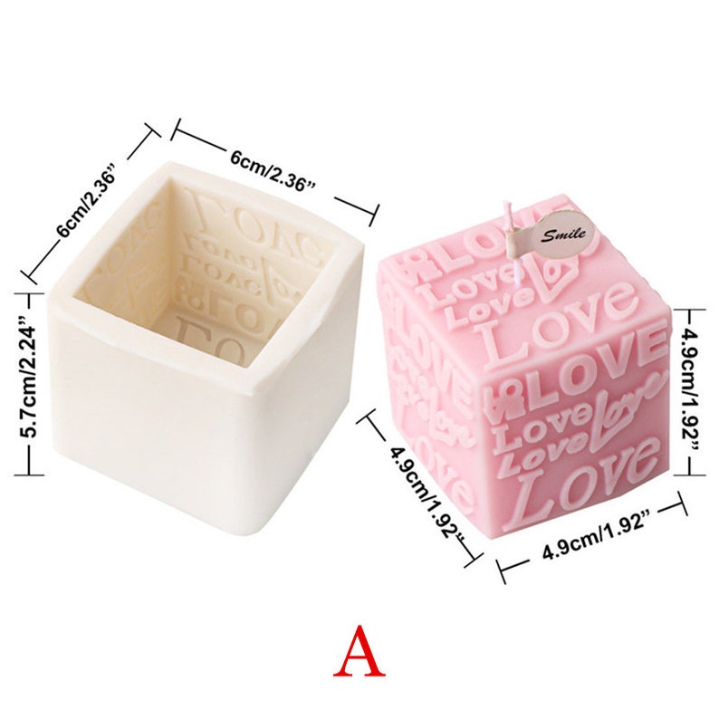 May include: A white silicone mold and a pink candle, both shaped like a cube. The candle is decorated with the word "Love" repeated in various sizes and orientations. The mold measures 5.7 inches by 6 inches. The candle measures 4.9 inches by 4.9 inches. The candle has a small tag that says "Smile".