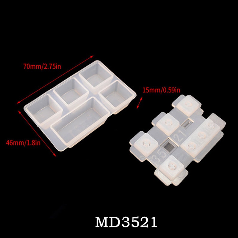 May include: Clear silicone mold for making resin keycaps. The mold has five sections, including a rectangular section and four square sections. The mold is 70mm by 46mm. A separate silicone mold for making keycaps is also shown. The mold has six sections, each with a number printed on it. The mold is 15mm wide. The text "MD3521" is printed below the molds.