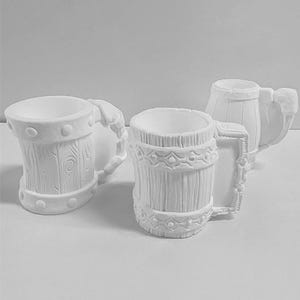 Puede incluir: Tres tazas de cerámica blanca con un diseño rústico. Las tazas tienen un asa y una abertura ancha. Las tazas son perfectas para servir bebidas.