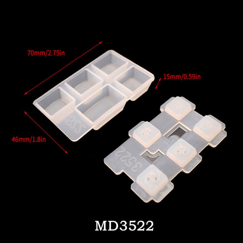 May include: A clear silicone mold for making keycaps. The mold has six rectangular cavities and measures 2.75 inches by 1.8 inches. The mold is shown next to a set of six clear silicone keycaps. The keycaps are labeled "MD3522".