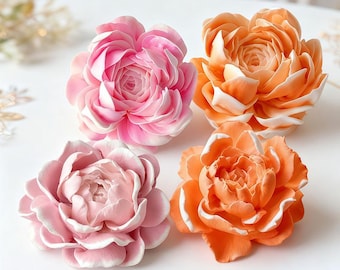 May include: Four decorative flower sculptures in shades of pink and orange. The flowers have multiple layers of petals with white accents. The arrangement includes two pink and two orange flowers, each with a detailed, realistic design.