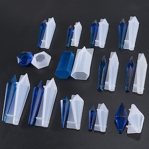 May include: A set of 15 silicone molds for making crystal-shaped resin crafts. The molds are in various shapes, including long, pointed, and round. The molds are white and the crystals are blue.