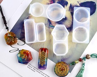 May include: Set of six clear silicone molds for making resin jewelry. The molds are shaped like a rectangle, a hexagon, a circle, and two different sized ovals.