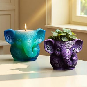 Może przedstawiać: Dwa dekoracyjne przedmioty w kształcie słonia. Jednym jest turkusowy świecznik ze świecą. Drugi to fioletowa donica z zielonymi roślinami. Oba mają szczegółowe rzeźbione wzory i znajdują się na białej powierzchni.