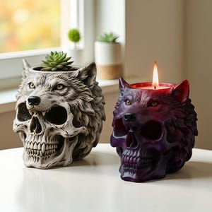 May include: Two decorative wolf-skull shaped items. One is a planter with a succulent, the other is a candle holder with a lit candle. The planter is off-white, and the candle holder is purple. Both have detailed wolf faces.