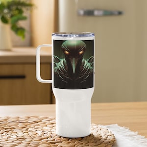 May include: White stainless steel travel mug with a black and green image of a creature with a beak and glowing eyes.