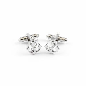 Può includere: Un paio di gemelli in metallo color argento con un design a forma di ancora dettagliato. Ogni ancora è impreziosita da una piccola pietra rotonda e trasparente incastonata sulla parte superiore. I gemelli presentano una chiusura a perno.