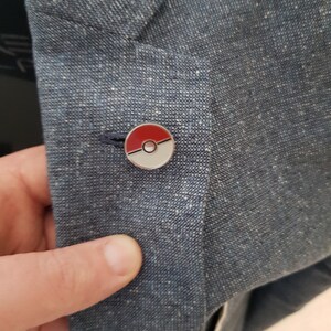 May include: A blue blazer with a red and white Pokeball pin.
