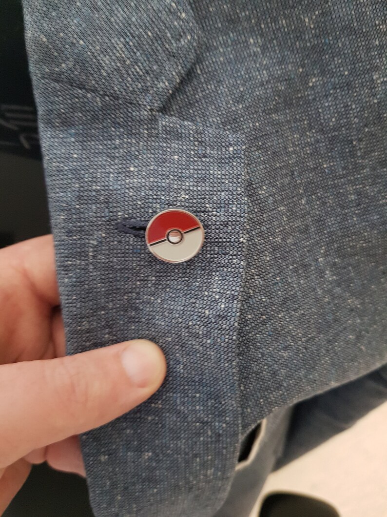 May include: A blue blazer with a red and white Pokeball pin.