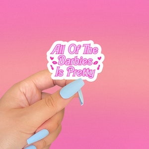 May include: A white sticker with pink text that reads "All Of The Barbies Is Pretty" with pink hearts and lipstick symbols.
