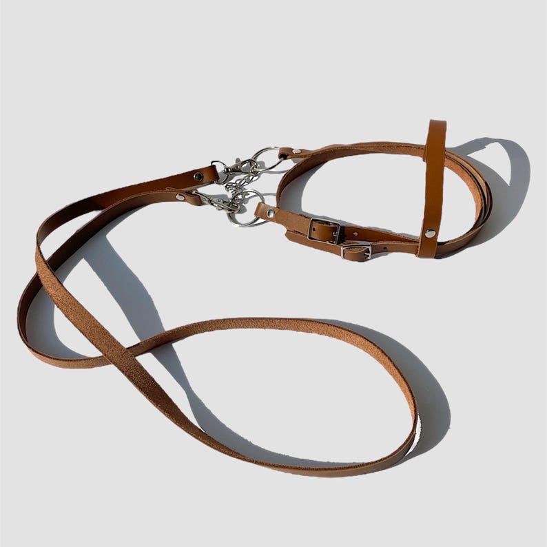 Puede incluir: Un bozal de cuero marr&oacute;n para perro con una correa de cuero a juego. El bozal tiene dos correas ajustables y una hebilla de metal. La correa es larga y tiene un clip de metal.