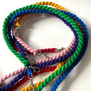May include: A set of six colorful, braided cotton ropes with silver clasps. The ropes are in shades of blue, green, yellow, red, and pink.