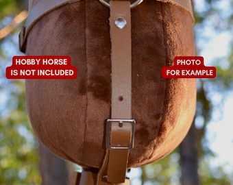 May include: Brown leather harness with a silver buckle and a ring. The harness is attached to a brown hobby horse, but the horse is not included. "Hobby Horse is not included" and "Photo for example" are written on the image.