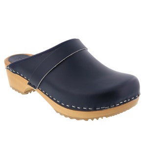 May include: A pair of navy blue leather clogs with a wooden sole and a strap across the top.