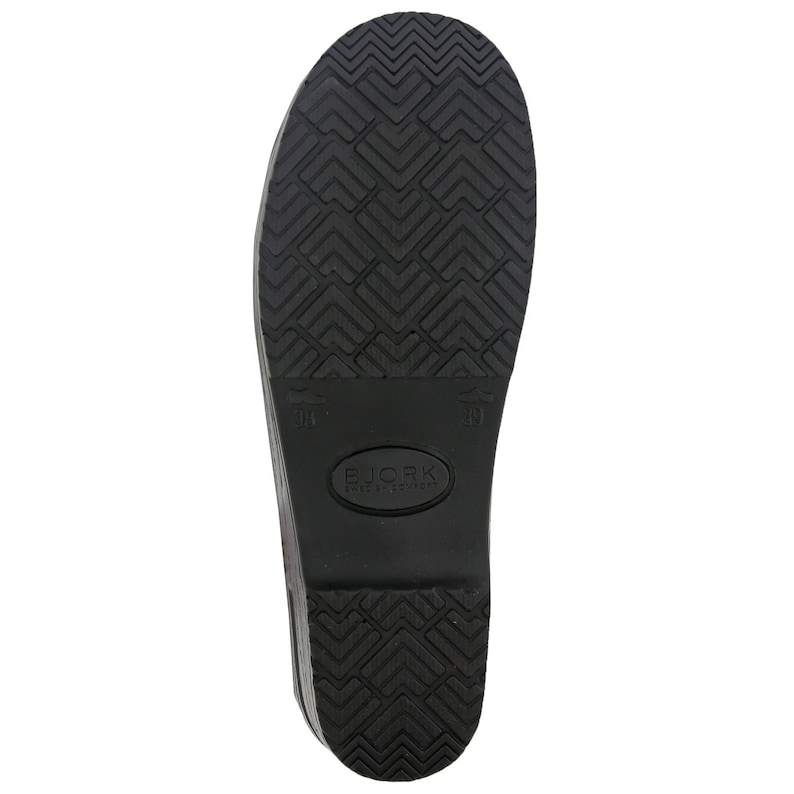 Op de afbeelding: Zwarte rubberen zool van een klomp met een ruitpatroon en de tekst "BJORK SHOES SWEDEN" in een witte ovaal.