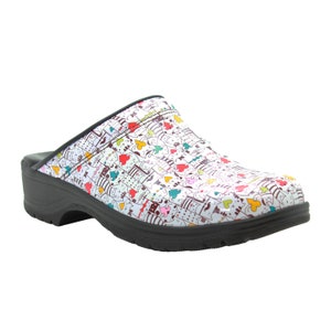 May include: White clogs with a black sole and a colorful print of cats and hearts.