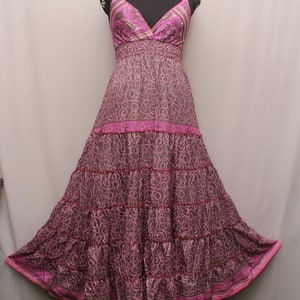 May include: A long, tiered maxi dress with a pink and brown floral print. The dress has a V-neckline and thin straps.