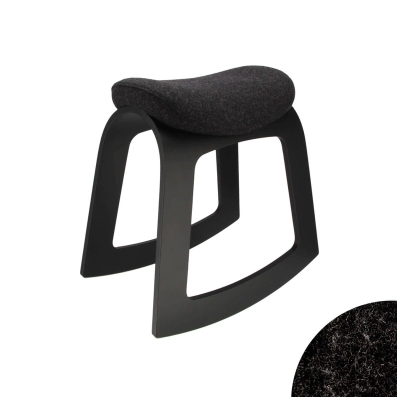Puede incluir: Taburete de madera negro con asiento de tela gris. El taburete tiene un dise&ntilde;o curvo y moderno.
