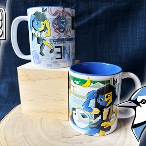 Può includere: Due tazze in ceramica bianca con disegni di personaggi dei cartoni animati colorati. Una tazza ha l'interno blu e un personaggio con caratteristiche gialle e blu. L'altra tazza ha l'interno bianco e un personaggio con caratteristiche blu e gialle.