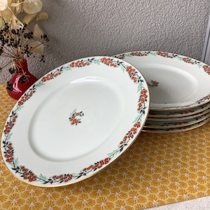 May include: Set of six white ceramic dinner plates with a gold rim and a floral design featuring red and green accents.