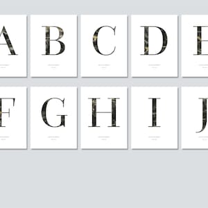 Op de afbeelding: Tien witte kunstdrukken met de letters A tot en met J. Elke letter is zwart met een marmer effect en is gecentreerd op de print. De prints hebben een minimalistisch ontwerp, geschikt voor interieurdecoratie.