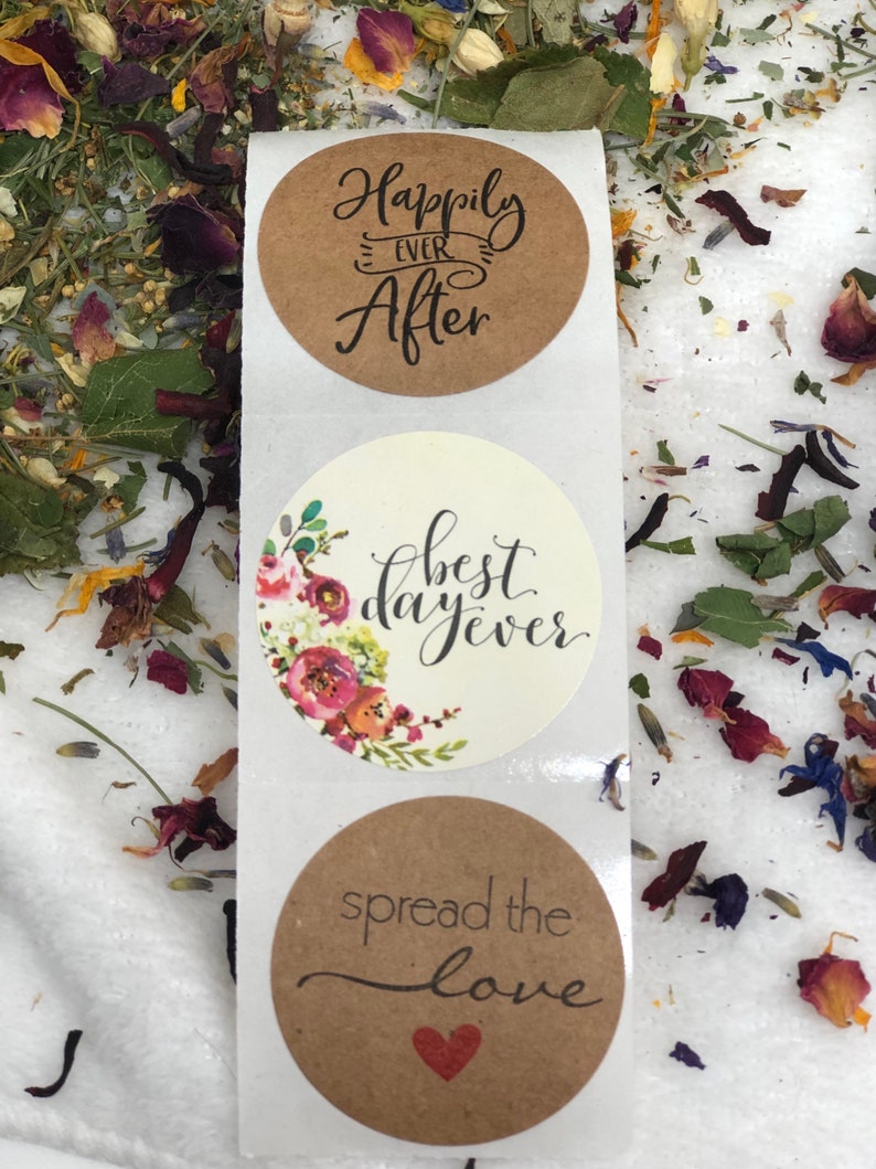 May include: Three round kraft paper stickers with wedding-themed text. The top sticker says "Happily Ever After". The middle sticker has a floral design and says "best day ever". The bottom sticker says "spread the love" with a red heart.