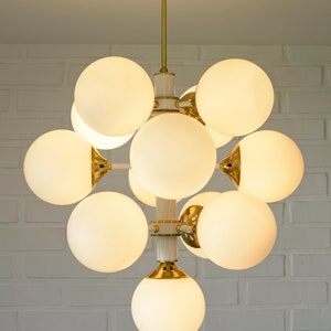 May include: A white and gold modern chandelier with 10 round frosted glass globes.