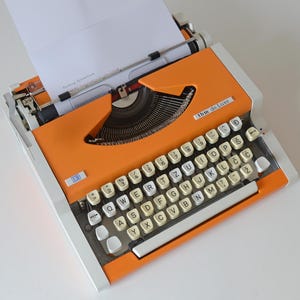 Vintage oranje werkende typemachine: midden van de eeuw modern UNIS, tbm de luxe, Joegoslavië, jaren 80