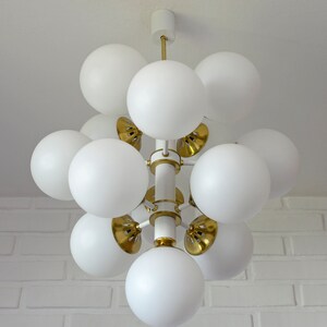 May include: A white and gold modern chandelier with multiple round white glass shades.