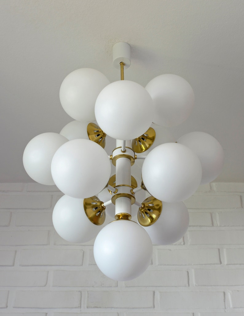 May include: A white and gold modern chandelier with multiple round white glass shades.