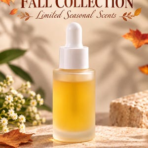 May include: A frosted glass dropper bottle filled with a golden liquid, topped with a white cap. The text "FALL COLLECTION" and "Limited Seasonal Scents" appears above the bottle, accompanied by orange and red maple leaf illustrations.