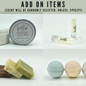 Może przedstawiać: Dodatki do kąpieli i pielęgnacji ciała, w tym słoik z balsamem oznaczony jako "Sweet Basil Eucalyptus & Tea Tree Handmade Lotion", tubka balsamu do ust z etykietą "Vanilla", trzy bomby kąpielowe w kolorze niebieskim, beżowym i szarym oraz trzy mydła w kolorze brązowym, białym i zielonym.