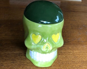 Ceramic skull jar - in greens and yellow.