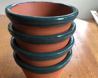 Four piece terracotta plant pot set with jade green glimmer fired glazed trim.