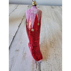 Adorno navideño vintage de cristal con medias rojas brillantes y flocado, ideal como adorno para árbol de Navidad.