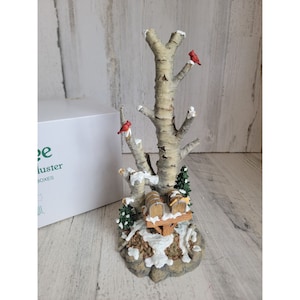 Puede incluir: Una escena de invierno en miniatura con un abedul, dos cardenales rojos y dos buzones de madera. La escena está cubierta de nieve y tiene un aspecto rústico.