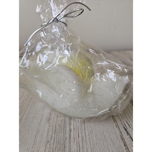 May include: A white, glittery, bird-shaped candle in a clear plastic bag with a silver ribbon.