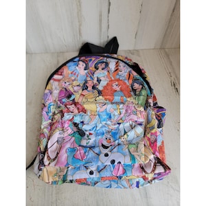 May include: A colorful backpack featuring a collage of animated princess characters. The backpack has a black top handle and straps, with a front pocket. The design includes various princesses in a vibrant, cartoon style, set against a light blue and pink background.