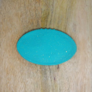 May include: A turquoise blue oval-shaped dish with gold glitter embedded in the surface.