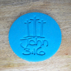 May include: Blue silicone mould with a design of three crosses and the text "John 3:16".