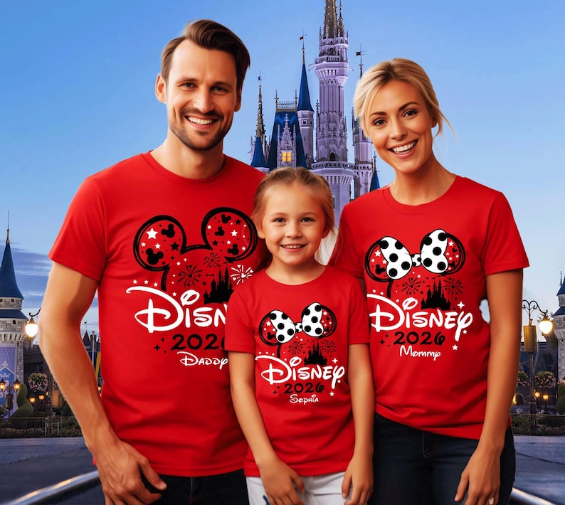 May include: Three red short-sleeved t-shirts featuring a black Mickey or Minnie Mouse ear silhouette graphic with white polka dots, fireworks, a castle outline, and the text Disney 2026. The shirts are personalised with Daddy, Mommy, and Sophia.