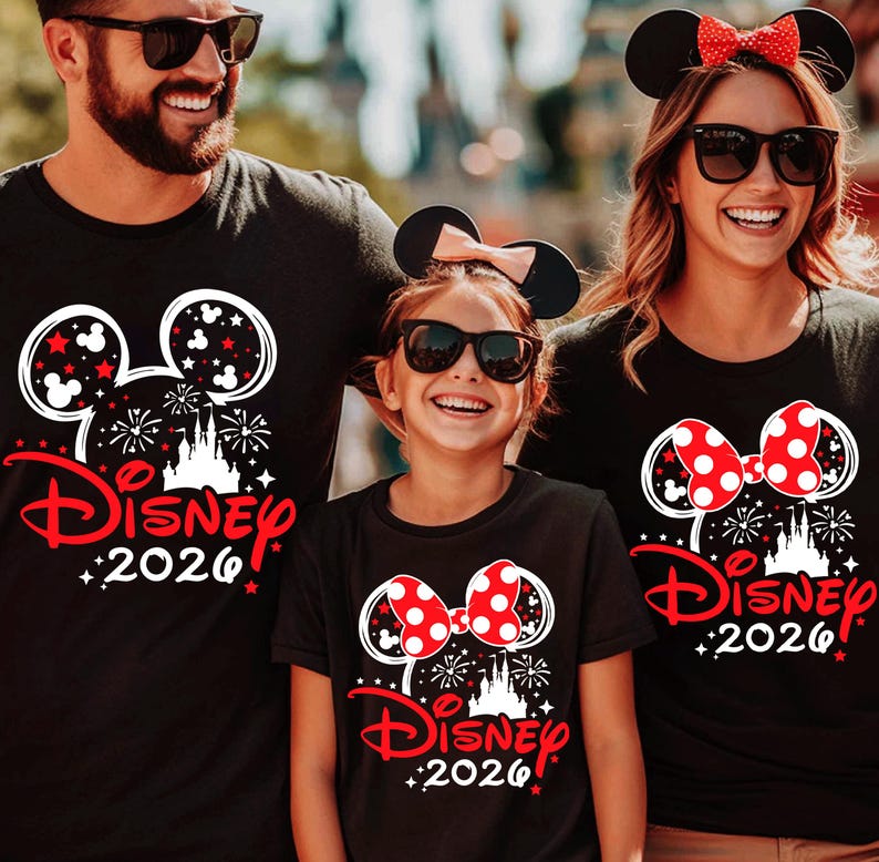 May include: Three black t-shirts featuring a white and red graphic of a castle, fireworks, and the text Disney 2026. The shirts display either a Mickey Mouse or Minnie Mouse ear design with a red polka dot bow on the Minnie versions.