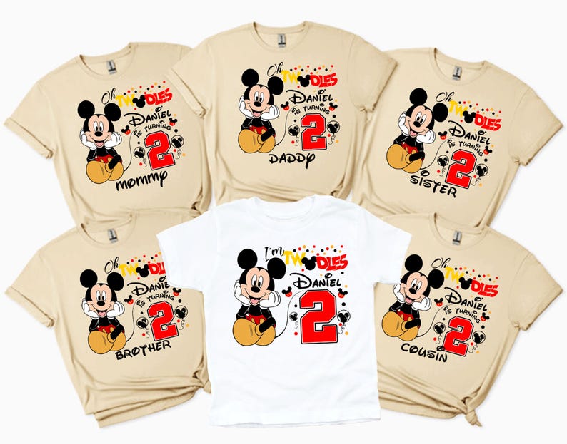 May include: A collection of beige and white t-shirts featuring a Mickey Mouse graphic. Each shirt has the text "Oh Twodles, Daniel is turning 2" with a family member's title: Mommp, Daddy, Sister, Brother, or Cousin.