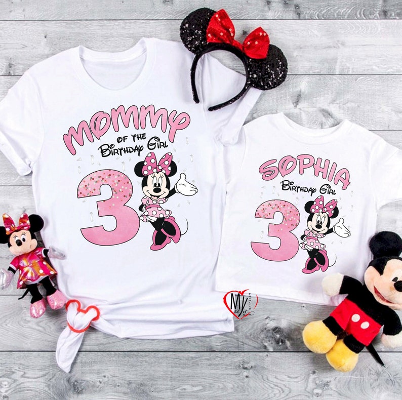 Puede incluir: Camisetas blancas con gr&aacute;ficos de Minnie Mouse. Una camiseta dice "Mommy of the Birthday Girl" y la otra "Sophia Birthday Girl". Ambas camisetas presentan un n&uacute;mero 3 rosa y Minnie Mouse. Accesorios: diadema de Minnie Mouse y peluches.