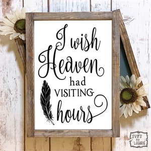 Pode incluir: Uma placa de madeira branca com texto preto que diz "Gostaria que o céu tivesse horários de visita". Uma pena preta está à esquerda do texto. A placa é emoldurada em uma moldura de madeira marrom rústica.