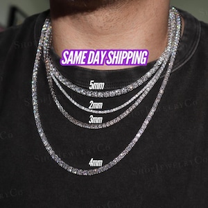 May include: Four silver-toned tennis necklaces featuring clear, round-cut stones arranged in a continuous line. The necklaces are labelled with widths of 2mm, 3mm, 4mm, and 5mm, showcasing varying thicknesses of the metal chains worn around the neck.